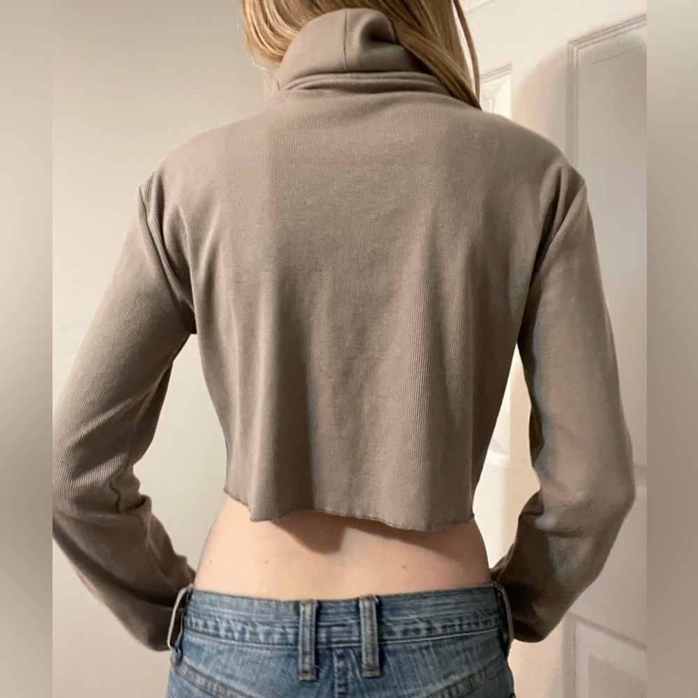 Turtleneck long sleeve crop top with rose embellishment.